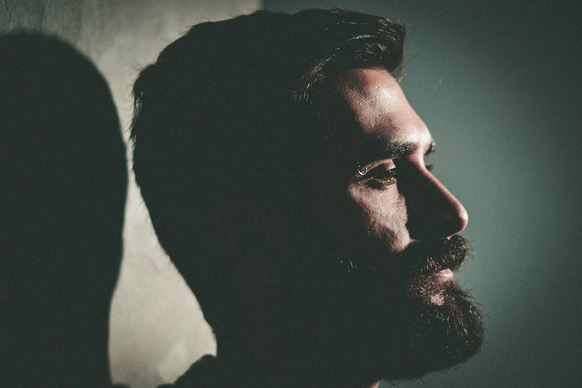 Primo piano di un uomo con barba e baffi per descrivere le tendenze di barba e baffi del 2023.